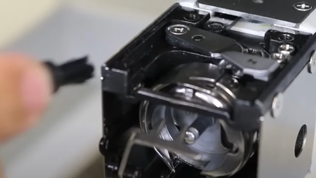 Cleaning the embroidery machine with a brush
