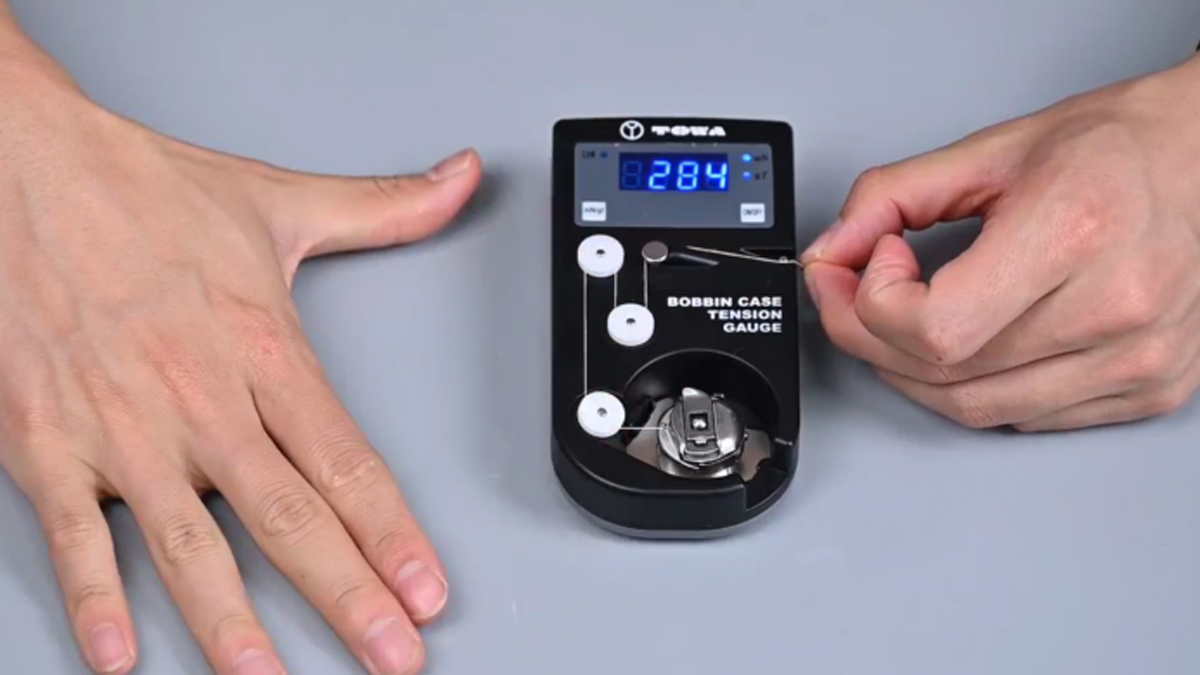 Steps for using an embroidery tension gauge.