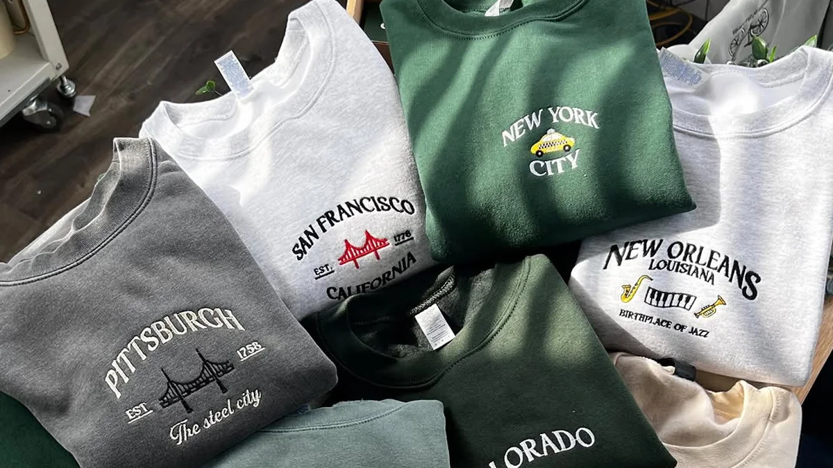 Embroidering various city letters and iconic patterns on sweatshirts.