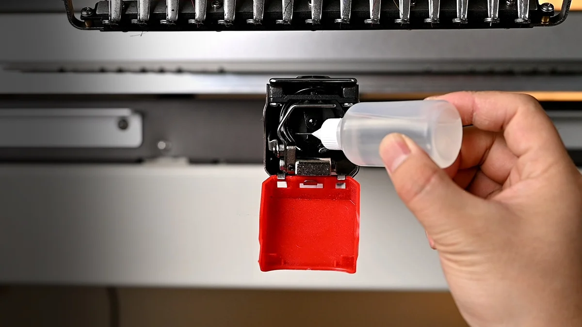Embroidery machine being maintained and oiled
